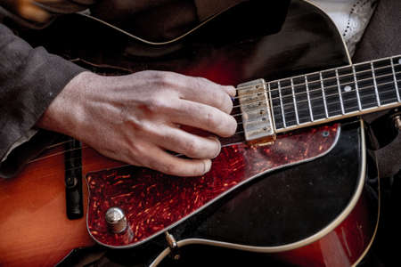 Close-up of a hand playing a guitar