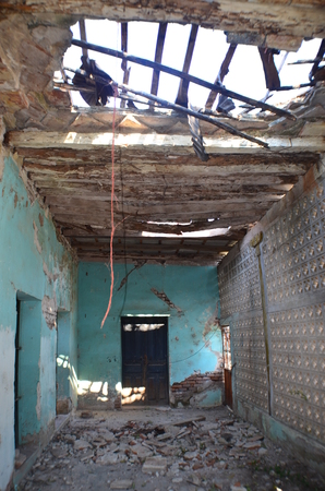 abandoned house with rubble on the ground and collapsed roofの写真素材