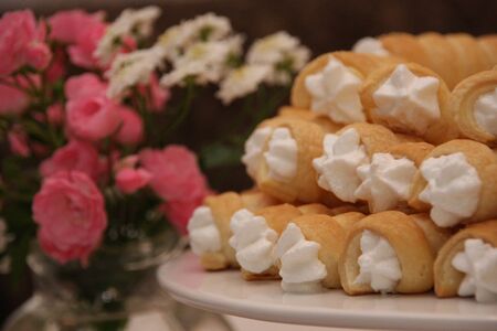 Delicious foam rolls or Schillerlocken Schaumrollen for sweet pastry arranged on white plate...