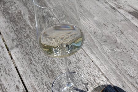 Wine glass and its shade on a wooden table, close up for conceptの写真素材