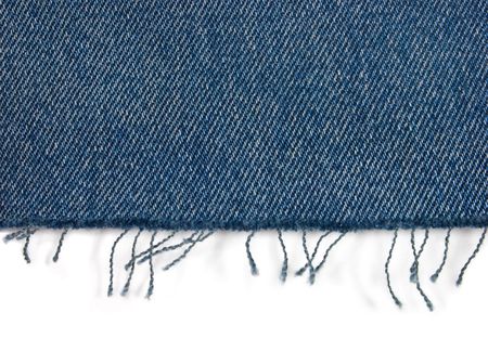 Edge of blue jeans fabric with fringe on white Edge of blue jeans fabric with fringe on white