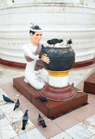 Statue of man with many birds in Shwedagon pagoda, Yangon (Rangoon), Myanmar (Burma).の写真素材