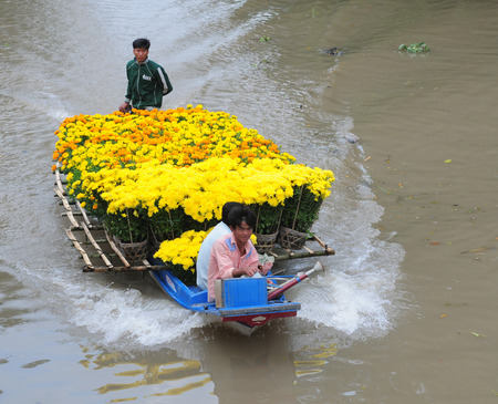 MEKONG DELTA, VIETNAM - JULY 20, 2014. Group of people sitting on motor boat, moving on canal, reflect on surface water, green tree at river, peaceful country, Vietnam.のeditorial素材