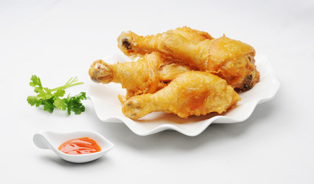 Fried chicken legs with chilli sauce and vegetablesの写真素材