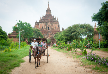BAGAN, MYANMAR - FEBRUARY 7, 2011. Tourist exploring the archeological site on a horse cart in Bagan. Bagan is famous for its thousands of temples, pagodas and stupas.のeditorial素材