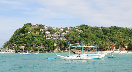 Boracay, Philippines - Feb 1, 2015. Tourists and traditional boat at White beach, Boracay Island,...