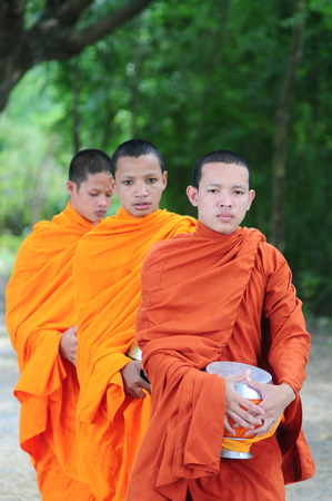 AN GIANG, VIETNAM - FEB 26 2015. Unidentified young monks walking morning alms in An Giang, Vietnam. Theravada Buddhism arrived from India into the southern Vietnam between 300-600 AD.のeditorial素材