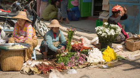 KALAW, MYANMAR - MAY 4, 2014. A flower vendor sets up her stall in Kalaw, Myanmar. Kalaw is one of the towns which holds a 5 day rotating market for locals to buy and sell goods.のeditorial素材