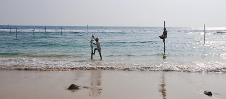 Hikkaduwa, Sri Lanka - Feb 1, 2012. Stilt Fishermen of Sri Lanka. Stilt fishing is a method of fishing unique to the island country of Sri Lanka, located off the coast of India.の写真素材