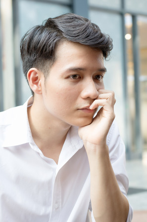 Portrait of young handsome man of Asian thinking and watching.の写真素材