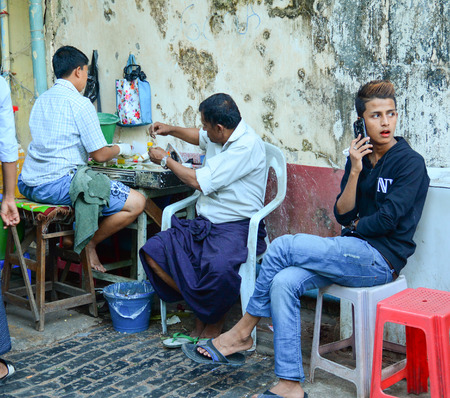 YANGON, MYANMAR - FEB 27, 2015. Burmese men at a coffee shops at Bogyoke Market in Yangon. Bogyoke Market was built in 1926 and was formerly known as Scott Market.のeditorial素材
