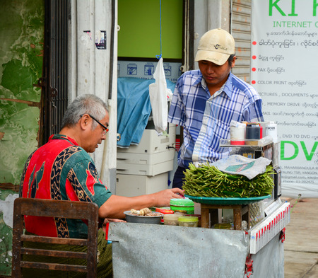 YANGON, MYANMAR - JAN 30, 2015. Busy street vendor selling breakfast and betel leaves at Yangon bus station in Myanmar (Burma).のeditorial素材