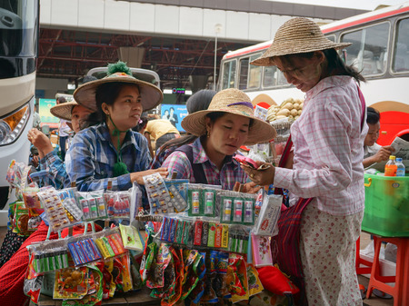 YANGON, MYANMAR - MARCH 10, 2015. Unidentified street pedlars selling local souvenirs have a chat in Yangon downtown, Myanmar.のeditorial素材