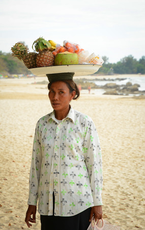 NGAPALI MYANMAR  JAN 16 2015. Unidentified woman selling fresh fruits at the shoreline to tourists in Ngapali beach. Selling products to the tourists is the main income for people in Ngapali.のeditorial素材