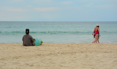 NGAPALI, MYANMAR - JAN 16, 2015. Unidentified women selling fresh fruits at the shoreline to tourists in Ngapali beach. Selling products to the tourists is the main income for people in Ngapali.のeditorial素材
