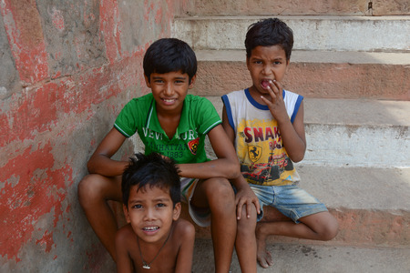 Varanasi, India - Jul 12, 2015. Unidentified young boys in an Indian village happily sitting on steps and looking at camera, Varanasi, India.のeditorial素材