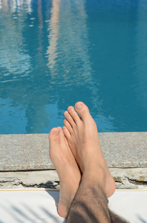 Asian man's feet in a swimming pool in Vietnam.の写真素材