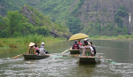 Tam Coc, Vietnam - Sep 3, 2015. People rowing boats for carrying tourists on Ngo Dong river of the Tam Coc National Park. Tam Coc is a popular tourist destination near the city of Ninh Binh in northern Vietnam.のeditorial素材