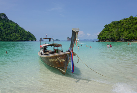 Krabi, Thailand - Sep 12, 2015. The traditional boats and tourists on the beautiful beach in sunny day in Krabi. Tourism is an important industry in Southern Thailand.のeditorial素材