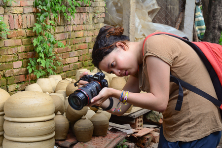 HOI AN, VIETNAM - MARCH 15, 2015. A young woman taking pictures on the street in Hoi An Ancient Town, Quang Nam, Vietnam.のeditorial素材