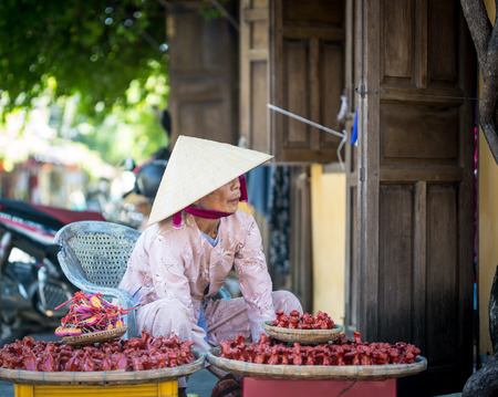 HOI AN, VIETNAM - MARCH 15, 2015. Unidentified woman selling souvenirs at walking street of old town with old aged traditionally kept cultural activities in Hoi An, Vietnam.のeditorial素材