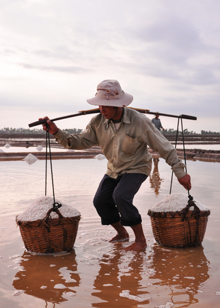 Kampot, Cambodia - Jan 25, 2012. A woman with hat on the salt field in Kampot, Cambodia.のeditorial素材