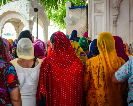 Amritsar, India - Jul 25, 2015. Indian women standing and praying at the Golden Temple in Amritsar, India. Golden Temple is the holiest Gurdwara of Sikhism.のeditorial素材
