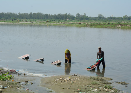 Agra, India - Jul 13, 2015. Indian men washing cloth on the sandy banks of Yamuna river, Agra, India. Agra is a city in northern Indiaâs Uttar Pradesh state.のeditorial素材