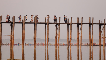 Mandalay, Myanmar - Feb 20, 2016. People walking on the Ubein bridge at sunset in Mandalay, Myanmar. U Bein Bridge is a crossing that spans the Taungthaman Lake in Myanmar.のeditorial素材