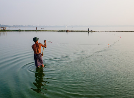 Mandalay, Myanmar - Feb 21, 2016. A Burmese man catching fish on lake in Mandalay, Myanmar.のeditorial素材