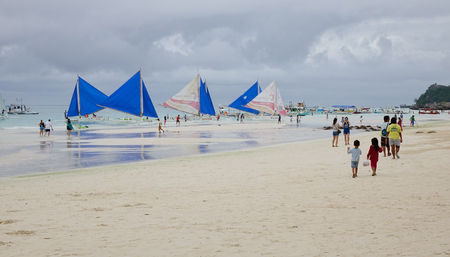 Boracay, Philippines - Dec 17, 2015. People with sailboats on White beach in Boracay, Philippines. Boracay is a tropical island surrounded by stunning white sand beaches.のeditorial素材
