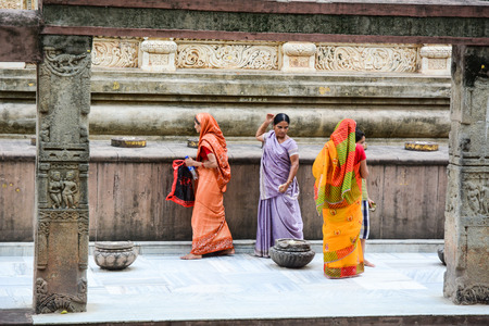 Bodh Gaya, India - Jul 9, 2015. Indian women in traditional saree walking and praying at Mahabodhi Temple in Bodh Gaya, India.のeditorial素材