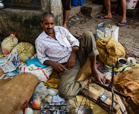 Bodhgaya, India - Jul 9, 2015. Unidentified man sitting in a crowded market in Bodhgaya, India. Its a common practice in India to sell vegetables in open markets and streets.のeditorial素材