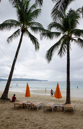 Boracay, Philippines - Dec 17, 2015. Relaxing chairs with palm trees on White beach at rainy day in Boracay, Philippines.のeditorial素材