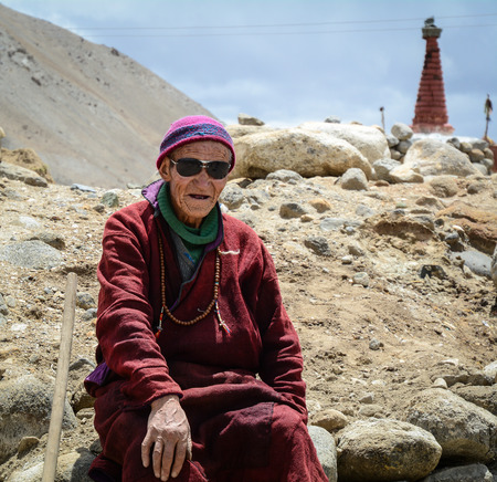 Ladakh, India - Jul 17, 2015. Tibetan monk sitting on the rocks in Ladakh, India. Ladakh is one of the most sparsely populated regions in Jammu and Kashmir.のeditorial素材