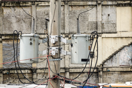 Old reinforced concrete pole with electrical wires in Philippines.