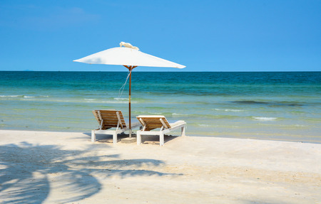 Idyllic tropical beach with relaxing chais and umbrella in sunny day at summerの写真素材