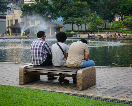 Kuala Lumpur, Malaysia - Jun 6, 2015. People sitting at city park in Kuala Lumpur, Malaysia. There are lots of budget hotels and cheap food in this neighborhood.のeditorial素材