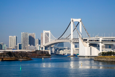 Tokyo, Japan - Jan 4, 2016. The Rainbow Brigde with modern buildings in Tokyo Bay, Tokyo, Japan. A number of Japan's most important ports are located in Tokyo Bay.のeditorial素材