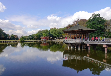 Nara, Japan - Nov 25, 2016. Tourists on the wooden pavilion over a pond during autumn in Nara, Japan.のeditorial素材