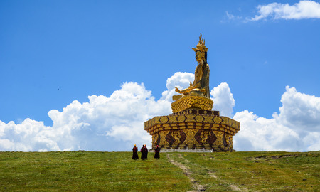 Big Buddha on the grass hill at Yarchen Gar Monastery in Garze Tibetan, Sichuan, China.