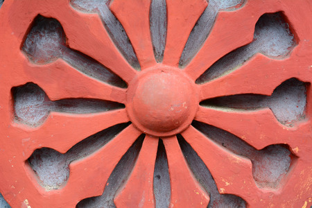 Dharma Wheel Buddhist symbol in old door of local temple in Vietnam.