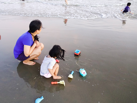 Vung Tau, Vietnam - Nov 12, 2016. Mother and daughter playing on the beach at sunset in Vung Tau, Vietnam. Vung Tau is one of famous destinations near Saigon.のeditorial素材