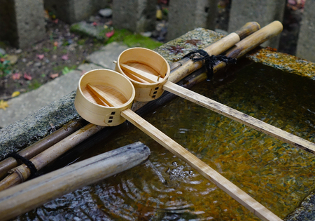 Japanese wooden ladles at Shinto temple in Kyoto, Japan. In Japan, a tsukubai is a washbasin provided at the entrance to holy places for visitors to purify themselves.の写真素材