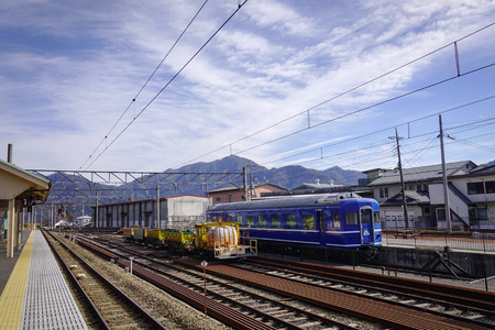 Kawaguchiko, Japan - Dec 4, 2016. A train on track at sunny day in Kawaguchiko, Japan. Fujikawaguchiko is a Japanese resort town in the northern foothills of Mount Fuji.のeditorial素材