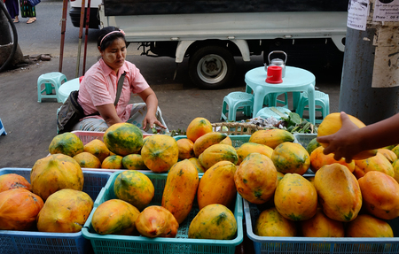 Mandalay, Myanmar - Feb 26, 2016. People selling papaya fruits at market in Mandalay, Myanmar. Mandalay is the second-largest city and the last royal capital of Myanmar (Burma).のeditorial素材