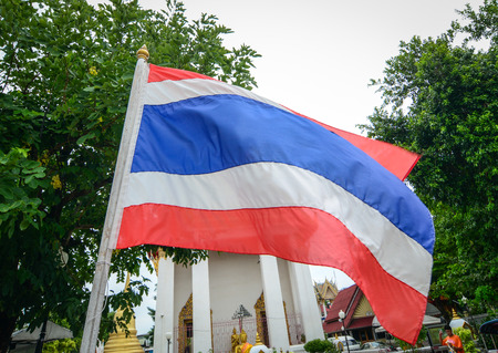 BANGKOK, THAILAND - JUL 30, 2015. A Thai flag in front of the Wat Mahathat in Bangkok, Thailand. Bangkok is a large city known for ornate shrines and vibrant street life.のeditorial素材