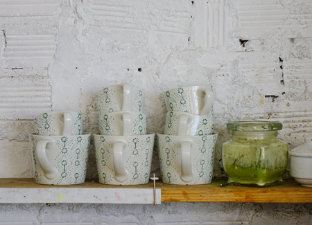Ceramic cups on wooden shelf at the kitchen. Close up.の写真素材