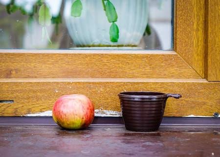 Apple and a cup with wooden window at village in Suzdal, Russia.の写真素材