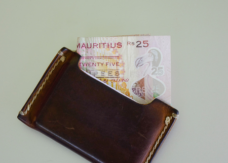Mauritian banknote (MUR - rupee) with brown wallet - close up.
